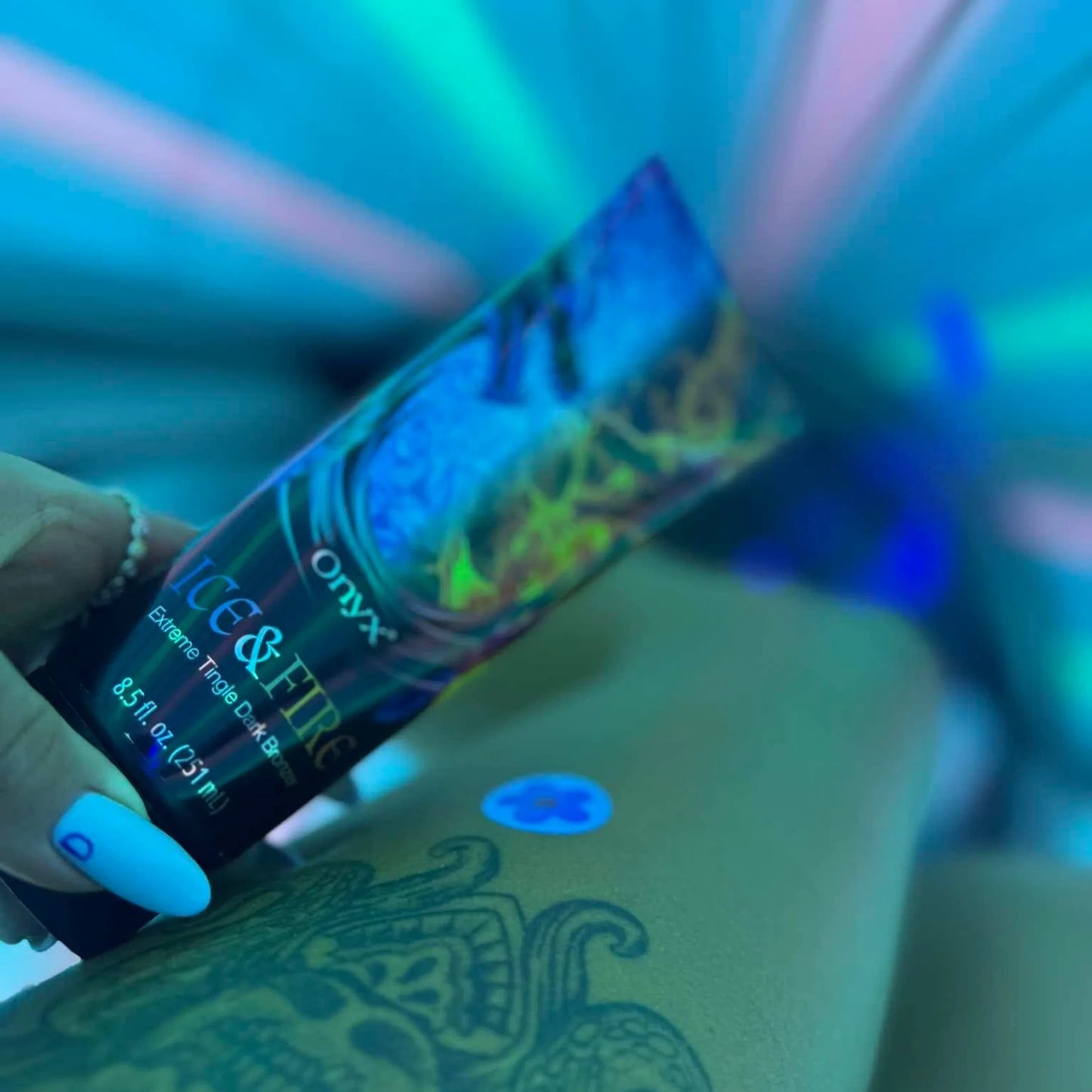 Ice & Fire Bräunungslotion auf Bein mit Tattoo während Solariumsitzung