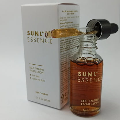 Bottle of facial tanning drops with a pipette placed next to a white product box on a plain background
