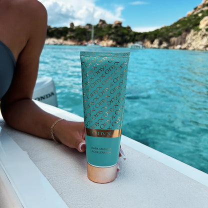 Onyx Dark Tanning Accelerator cream placed on boat with turquoise sea and sunny sky