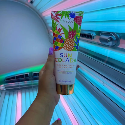 Onyx Suncolada tanning accelerator cream held upright inside sunbed