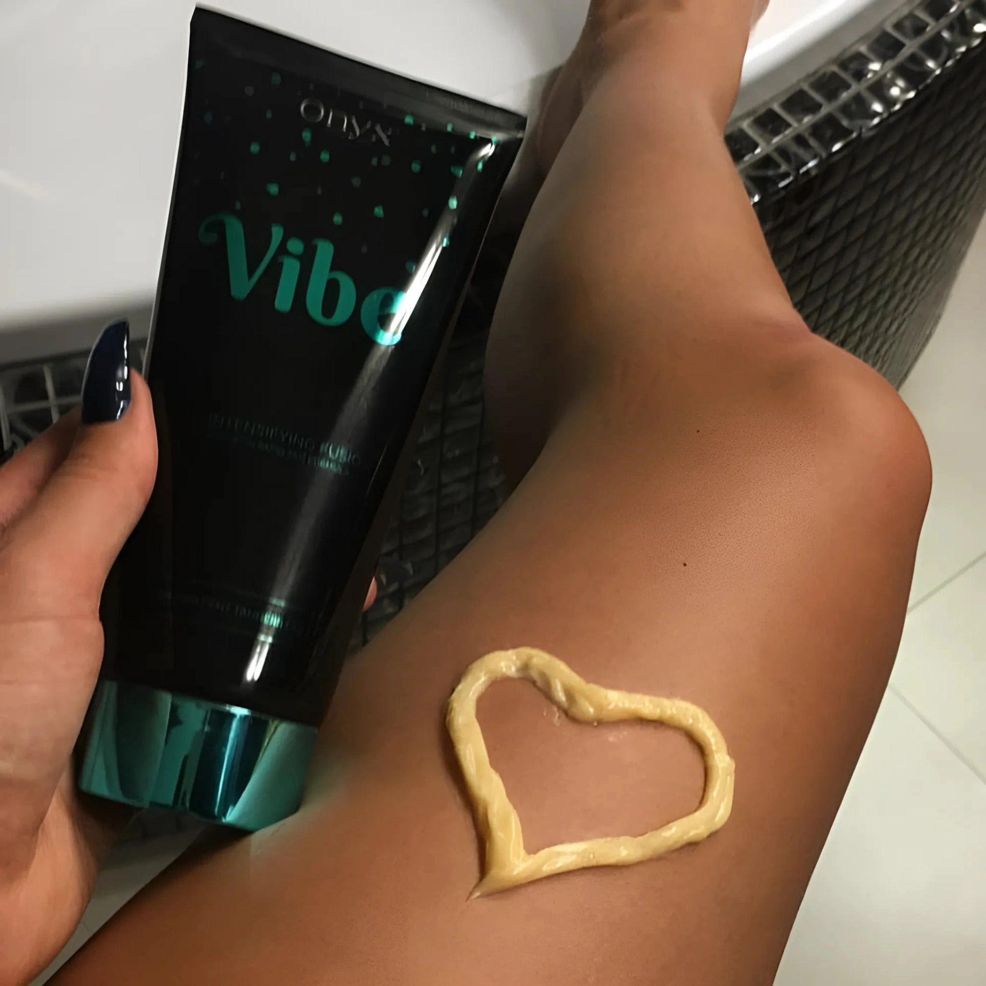 Onyx Vibe tanning accelerator cream applied on leg in heart shape for smooth tan effect